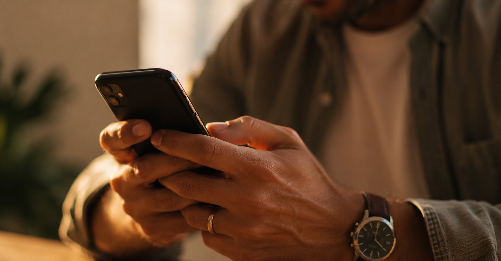 Close-up of a person's hands holding a smartphone in soft natural light